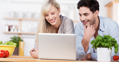 Husband and wife leaning on their granite benchtop in Central Otago